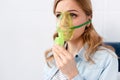 Asthmatic woman using respiratory mask, one