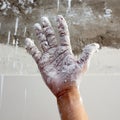 Astist plastering man hand with cracked plaster
