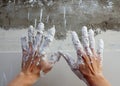 Astist plastering man hands with cracked plaster