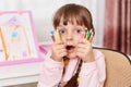 Astonished child, little girl with scared expression, being in panic, looking at camera with widely opened mouth and big eyes,