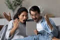 Astonished couple gawp at digital tablet feel amazed by news Royalty Free Stock Photo