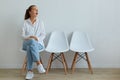 Astonished female wearing casual clothing sitting on chair and looking away with widely open mouth, sees something shocked, being Royalty Free Stock Photo