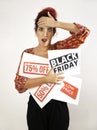 Astonished girl with open mouthed placing one hand on her head and with the other hand holding Black Friday signs, 75% off, 50%