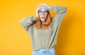 Astonished happy girl with hands on his head, isolated on yellow background. Positive news. Ecstatic pretty woman