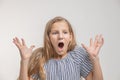 Astonished, happy young blonde looking away from arousal. Isolated over light wall background