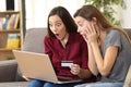 Astonished roommates buying on line at home Royalty Free Stock Photo