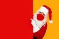 Astonished santa claus wearing a red face mask pointing to a red blank space Royalty Free Stock Photo