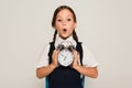 astonished schoolkid showing large alarm clock