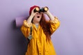 Astonished surprised young ginger woman looking through the binoculars Royalty Free Stock Photo