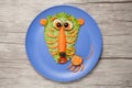 Astonished tiger made of salad and carrot on plate and table