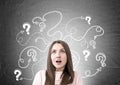 Astonished woman in pink, question marks, arrows Royalty Free Stock Photo