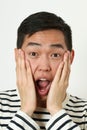 Astonished young Asian man covering his face with palms Royalty Free Stock Photo