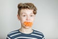 Astonished young boy with a mouthful of carrot