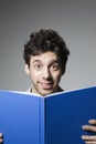 Astonished Young Male With Eyes Wide Open Holding Book