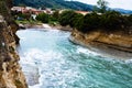 Astonishing landscape of waves crashing into breakwaters with a two storey house in the background. Gorgeus Ocean Surrounded by cl