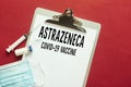 Astrazeneca USA COVID-19 vaccine. medical mask and syringe on red background