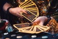 Astrology and cartomancy. A fortune teller holds a fan of Tarot cards. On the table are runes. Close-up of hands Royalty Free Stock Photo