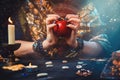 Astrology and divination. A fortune teller holds a red apple in her hands. On the table lay runes, candles, talismans. Close-up of