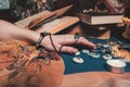 Astrology and esotericism. The female hand of the sorceress reads the runes. In the background, old books, fortune-telling runes,