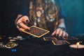 Astrology and esotericism. The female hand of the sorceress throws a Tarot card. Close up Royalty Free Stock Photo