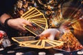 Astrology and esotericism. A fortune teller holds a fan of Tarot cards. On the table are runes and magic glass pyramid. Close-up Royalty Free Stock Photo