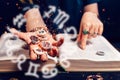 Astrology and horoscope. Fortune teller's hand holds the sparkling zodiac stones in the palm of her hand over the open