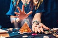 Astrology and magic. A fortune teller holds stones with the sign of the zodiac in her hands and conjures a magic pyramid