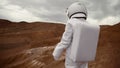 Astronaut explores an unknown red planet. Cloudy sky and mountains in the background