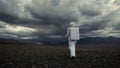 Astronaut explores an unknown red planet. Cloudy sky and mountains in the background