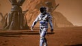 Astronaut goes on the surface of Mars through a dust storm past the giant solar panels. Panoramic landscape on the