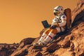 Astronaut with laptop sitting on rocky Mars-like terrain.