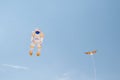 An astronaut and a little dragon kite at the kite festival at the storage sea geeste germany