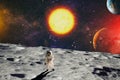 Astronaut looks up at an alien sun that illuminates the barren world he stands on. Elements of this image furnished by NASA