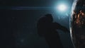 Astronaut man silhouette against realistic Earth