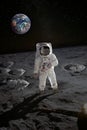 Astronaut on the moon surface with planet Earth behind. Royalty Free Stock Photo