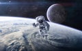 Astronaut in outer space against the background of the Earth`s landscape and the Moon. Solar system. Science fiction