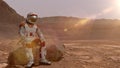 Astronaut sitting on Mars and admiring the scenery. Exploring Mission To Mars. Futuristic Colonization and Space Exploration