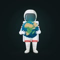 Astronaut standing holding planet Earth in both hands isolated on a dark background