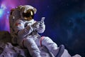 Astronaut using smartphone sitting on an alien planet surface with space background