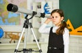 Astronaut Using Telescope. School astronomy lesson. Exploring space of new galaxies. School girl looking through Royalty Free Stock Photo
