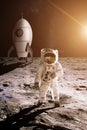 Astronaut is walking on the moon on background of toy rocket. Royalty Free Stock Photo