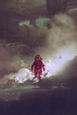 Astronaut walking through smoke on planet with sci-fi buildings on background