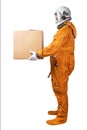 Astronaut wearing orange space suit and space helmet holding in hand brown cardboard box isolated on a white background Royalty Free Stock Photo