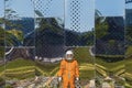 Astronaut wearing orange spacesuit and space helmet near the mirror wall with reflections Royalty Free Stock Photo
