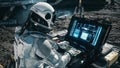 An astronaut works on his laptop at a space base on one of the new planets. 3D Rendering.