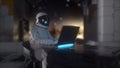 Astronaut works on his science laptop in futuristic spaceship, room. 3d rendering