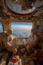 Astronauts engaged in a chess game inside a spacecraft, with a stunning view of Earth visible through the large windows, Royalty Free Stock Photo