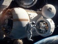 Astronauts work in outer space on the outer shell of the space station.