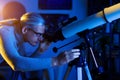 Astronomer man looks through telescope