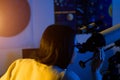 Astronomer woman looks through telescope